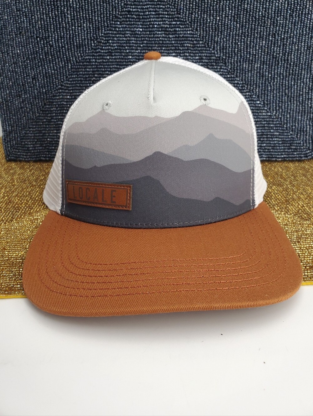 LOCALE Ranges Trucker Cap in the "Ranges Grey / Dark Orange" colorway